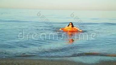 一个身穿泳装的黑发女人在靠近海岸的海域游泳。